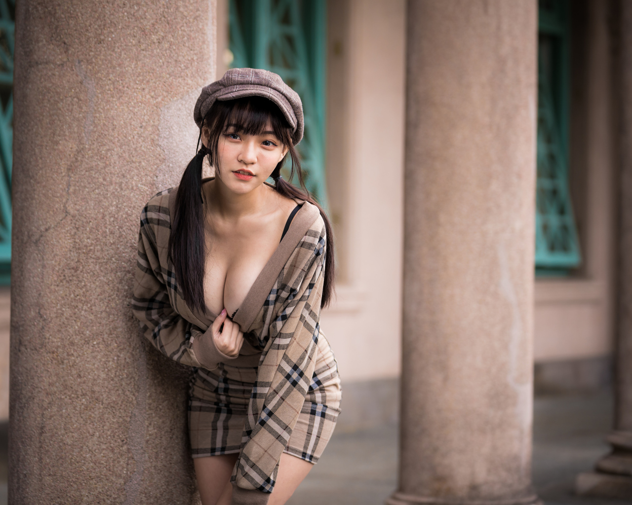 Сексуальная девушка азиатка стоит у колонны 