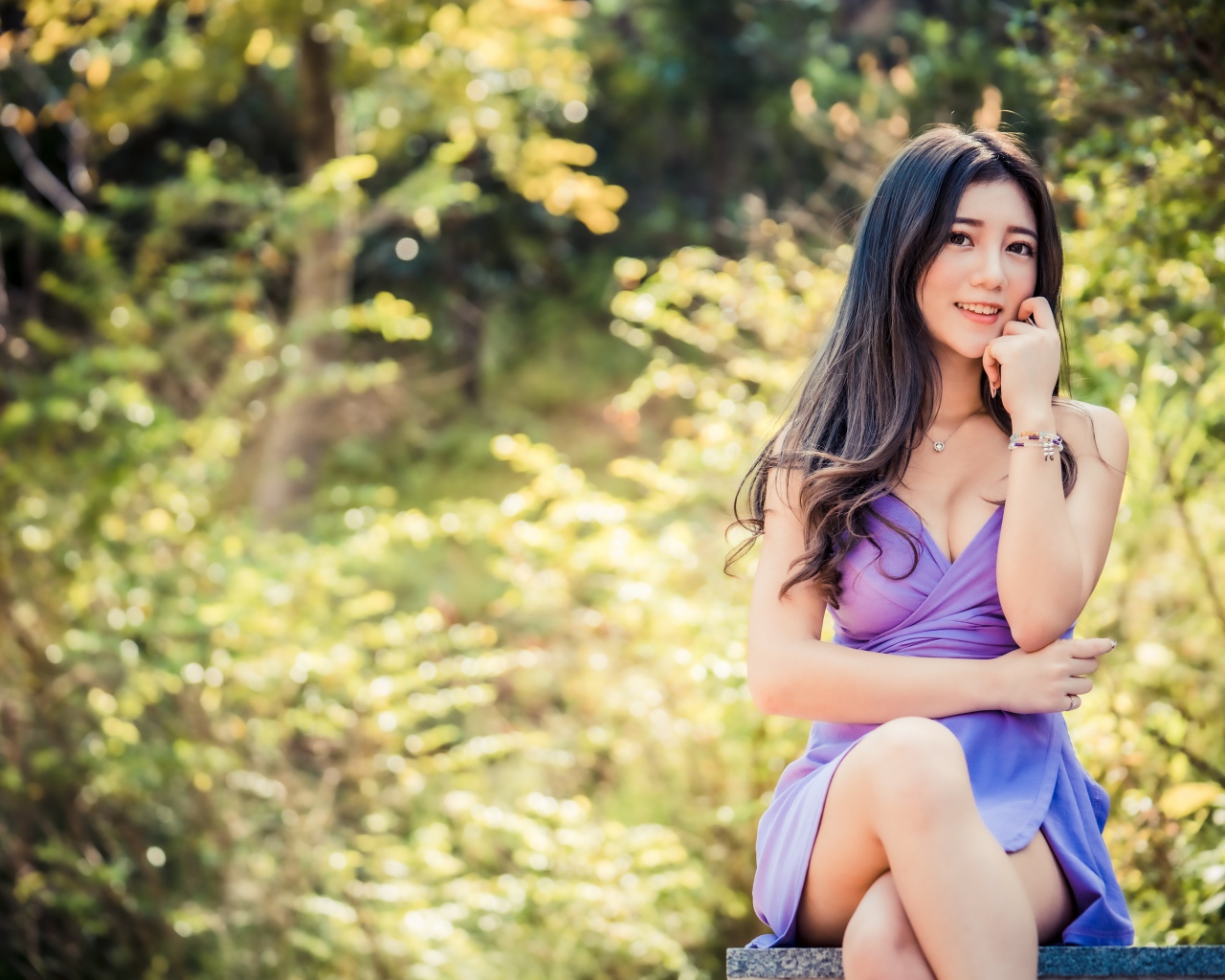 Улыбающаяся девушка азиатка в сиреневом платье