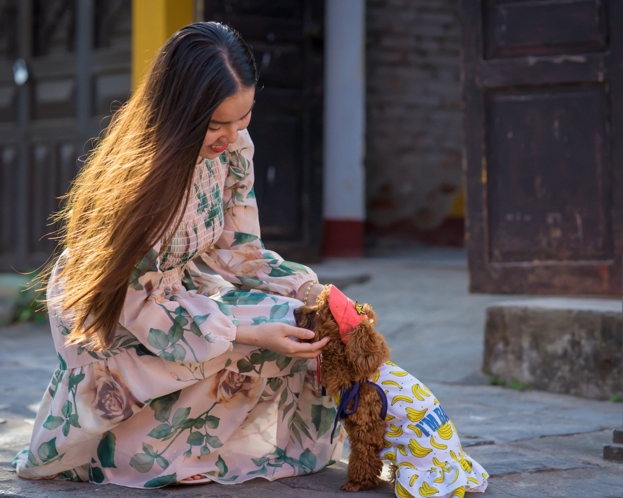 Улыбающаяся девушка азиатка с собакой 