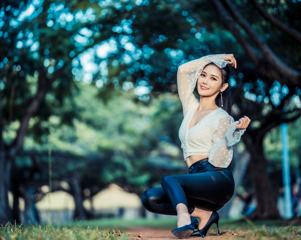 Улыбающаяся азиатка в черных брюках