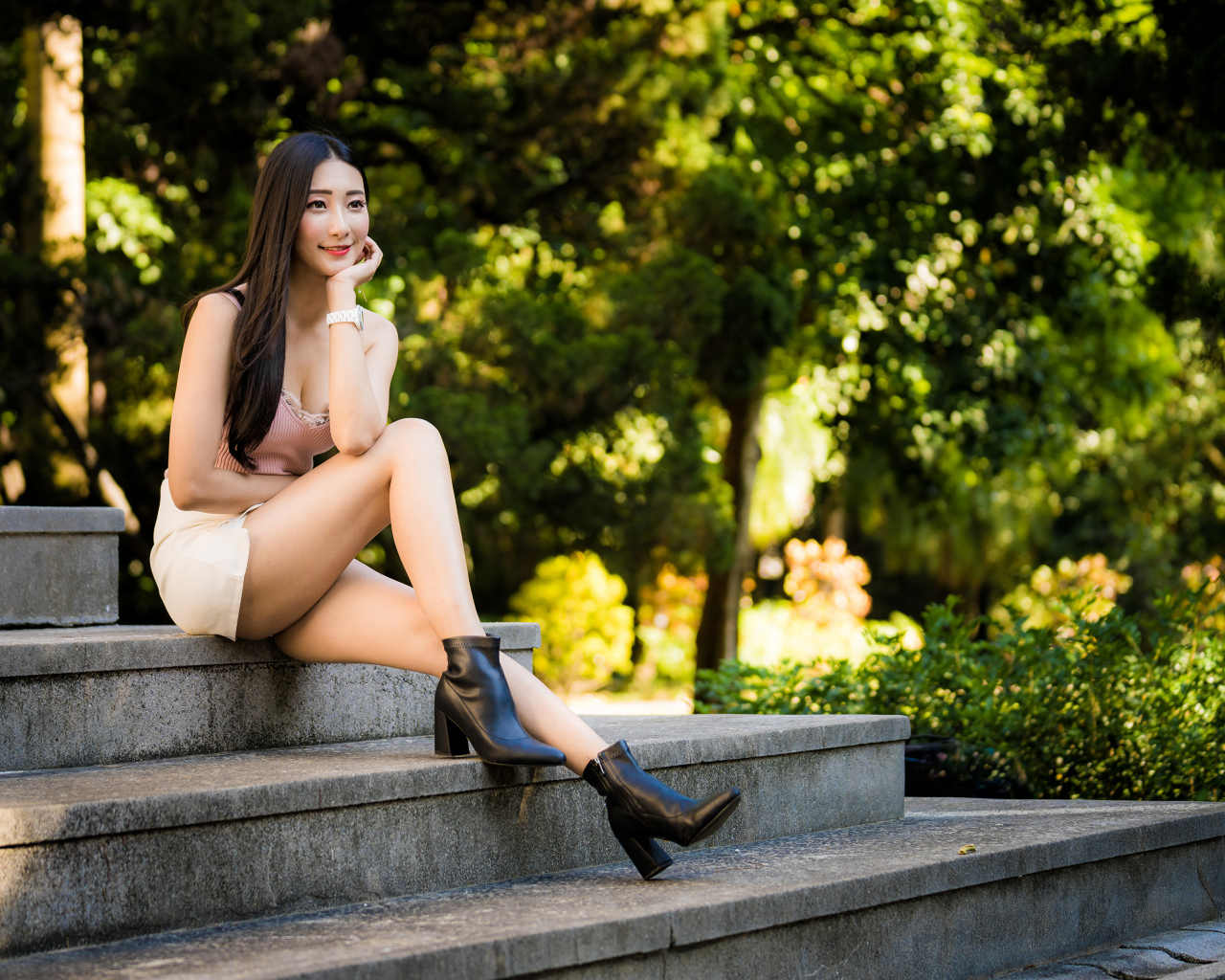 Улыбающаяся азиатка сидит на ступеньках