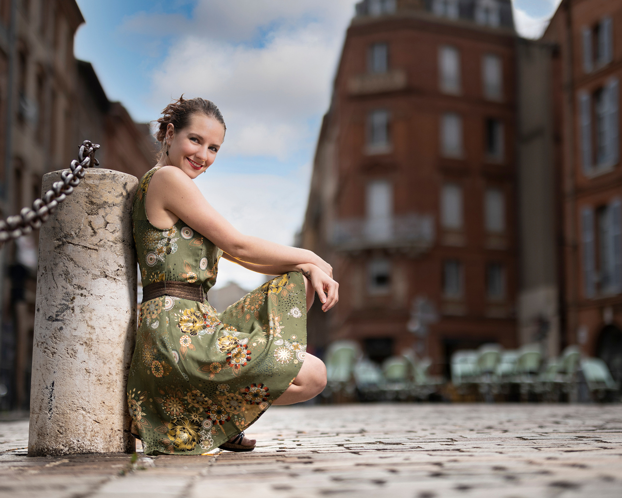 Улыбающаяся девушка в платье на улице города