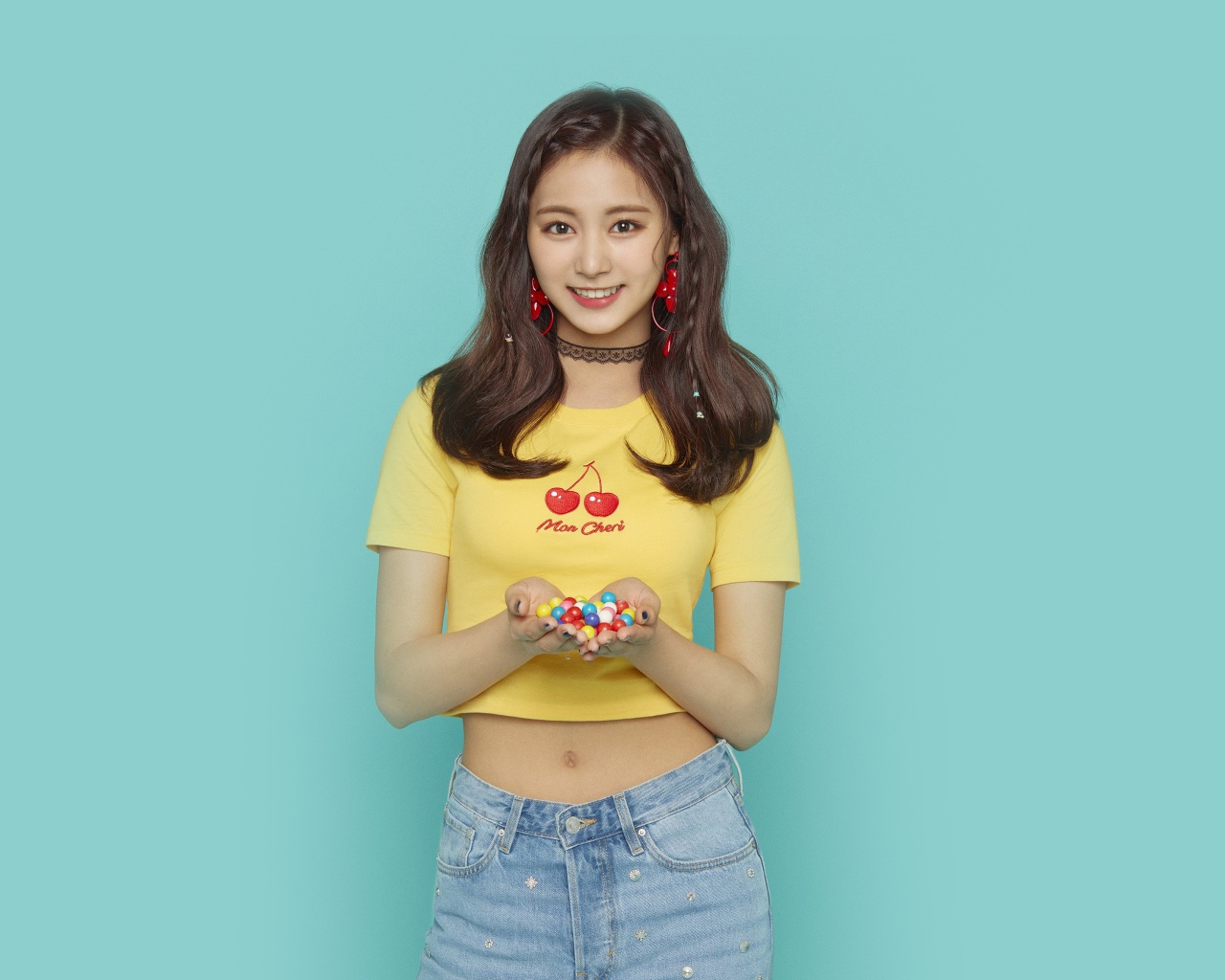 Улыбающаяся девушка с конфетами в ладонях на голубом фоне 