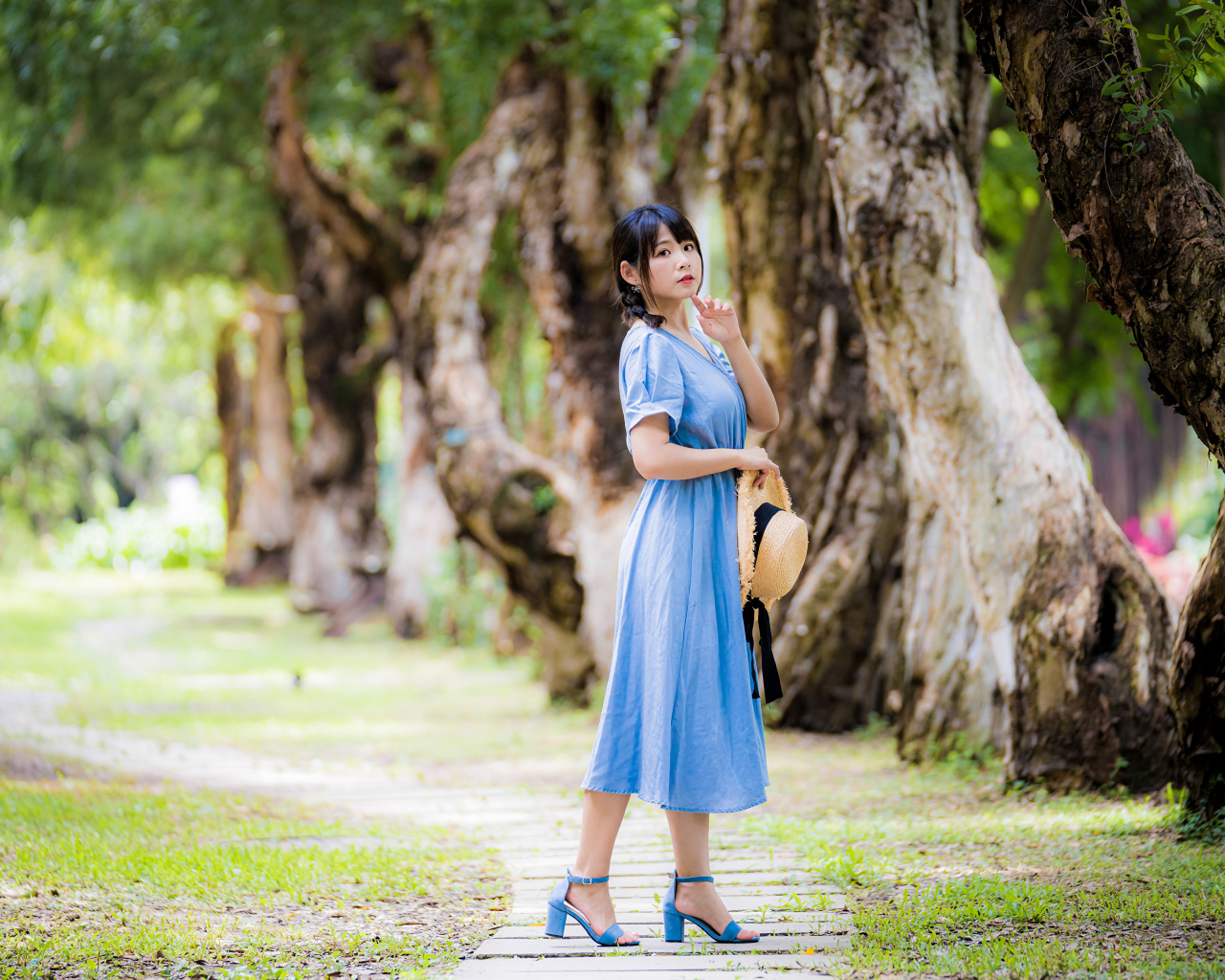 Стильная девушка азиатка в голубом платье в парке 