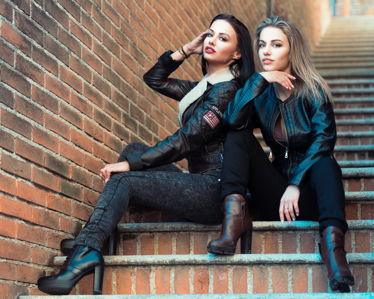 Две красивые девушки сидят на ступенях 
