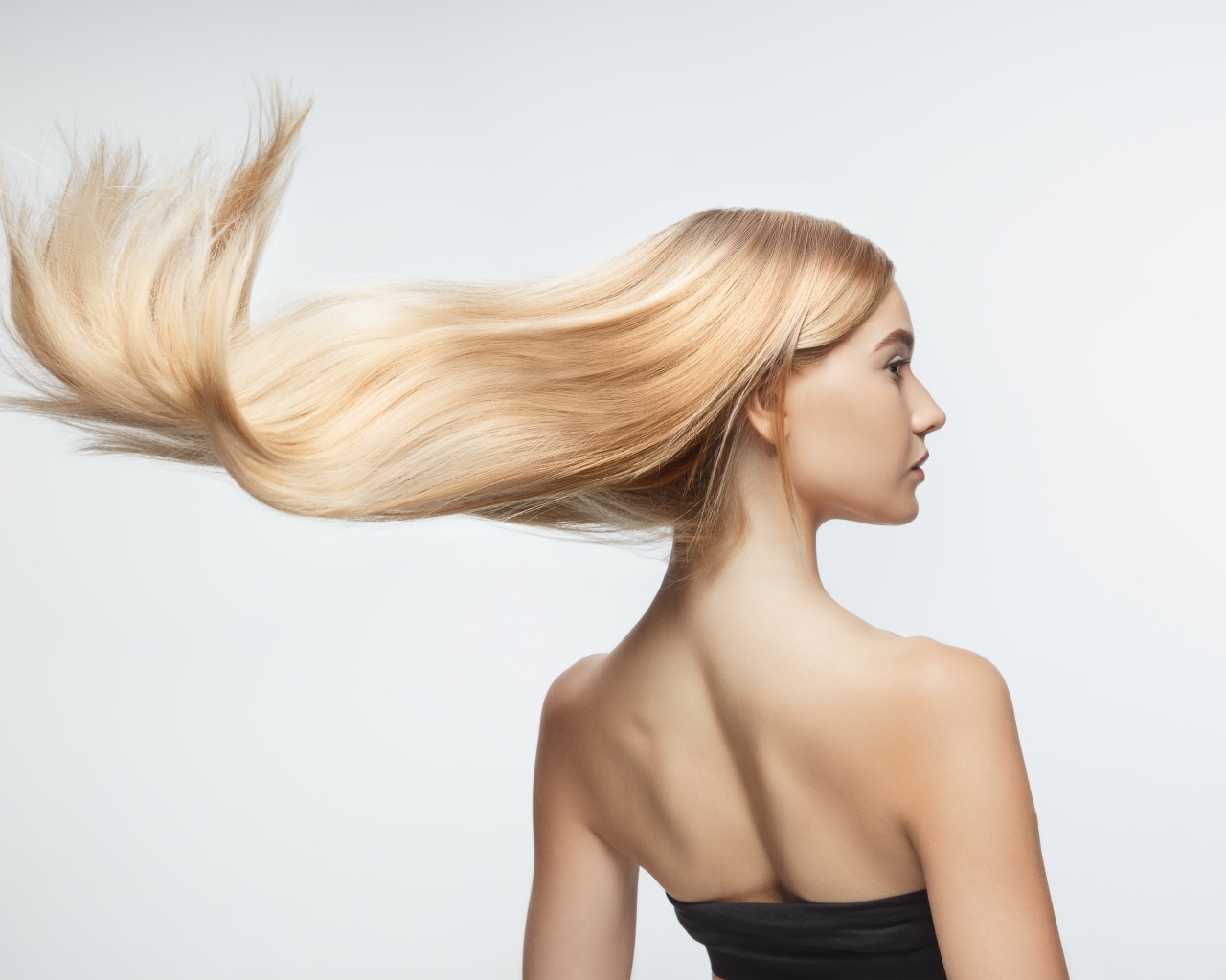 Белые волосы девушки развиваются на белом фоне 