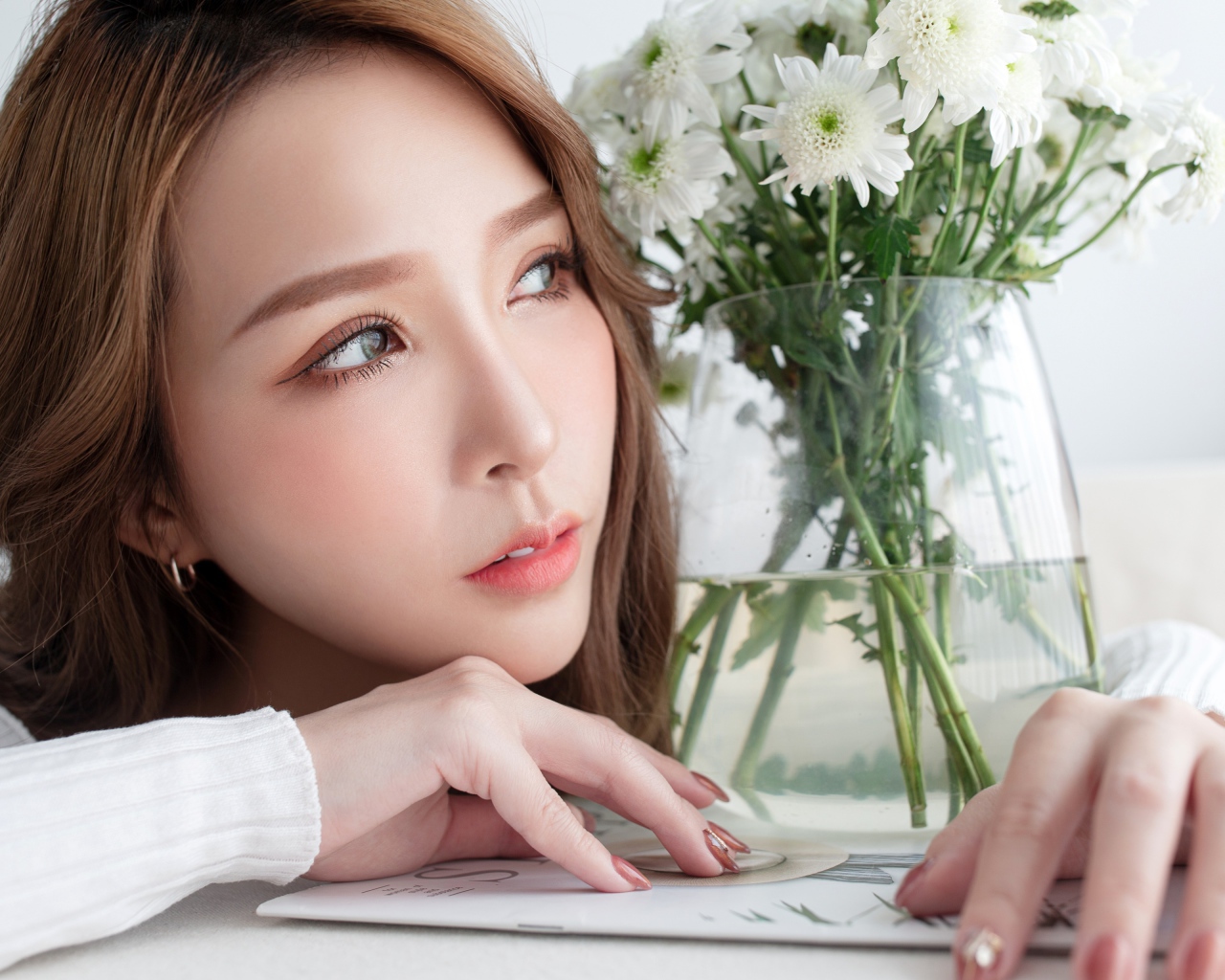 Молодая азиатка с букетом белой хризантемы в вазе