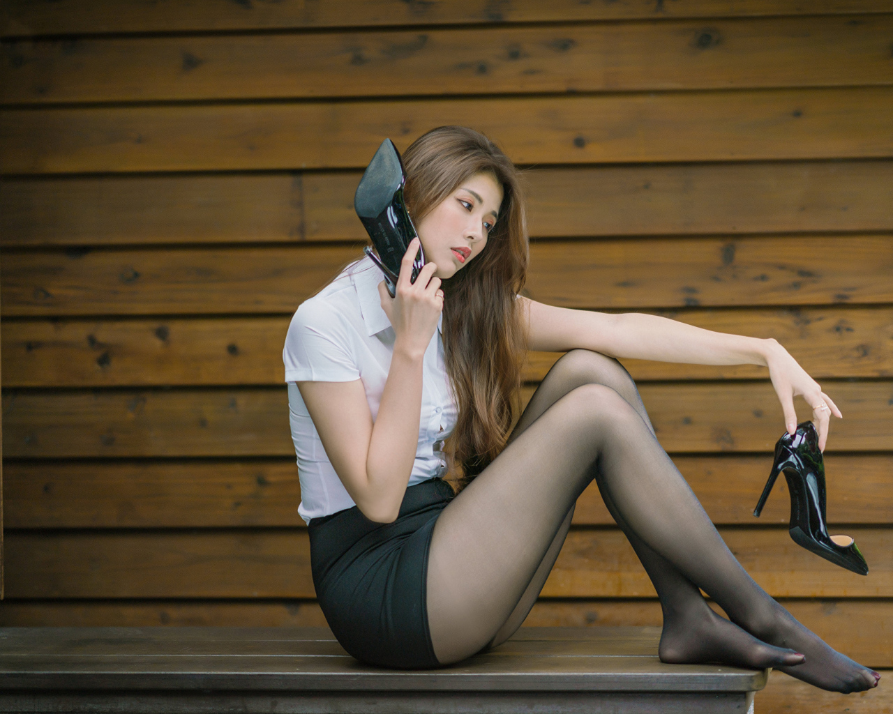 Молодая азиатка с черными туфлями в руках 