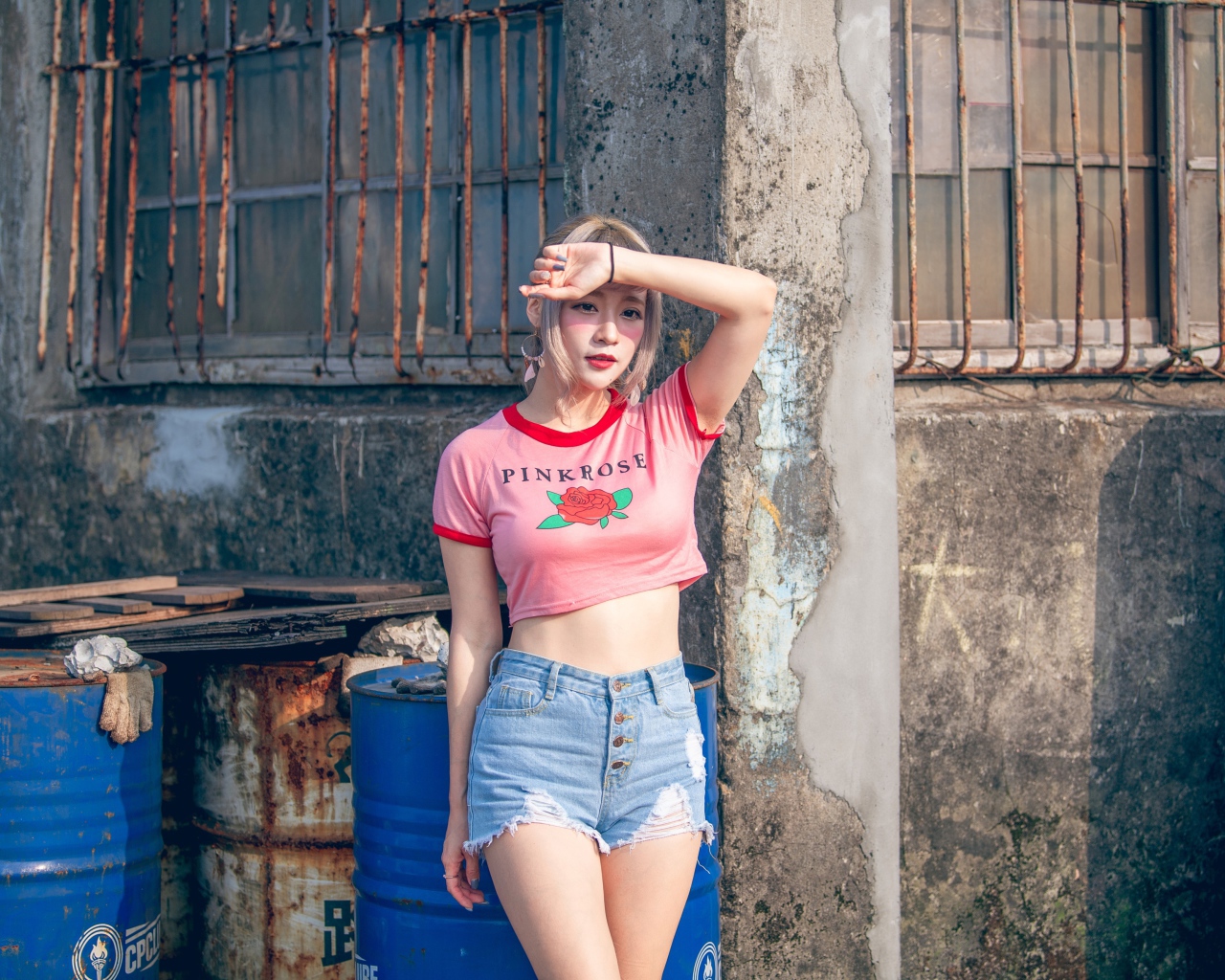 Молодая азиатка стоит у стены 