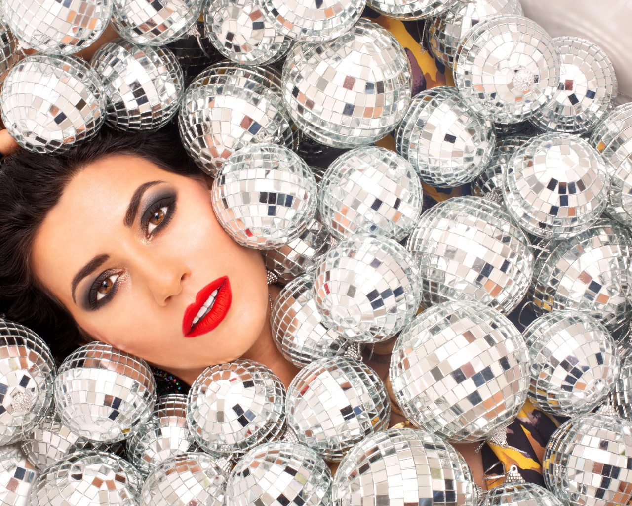 Молодая девушка усыпана блестящими шарами