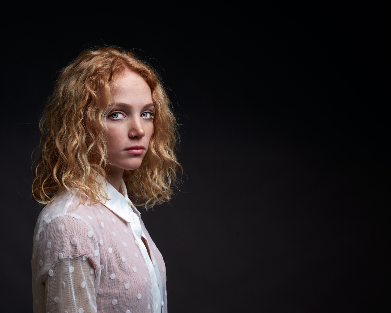 Молодая рыжеволосая девушка на черном фоне