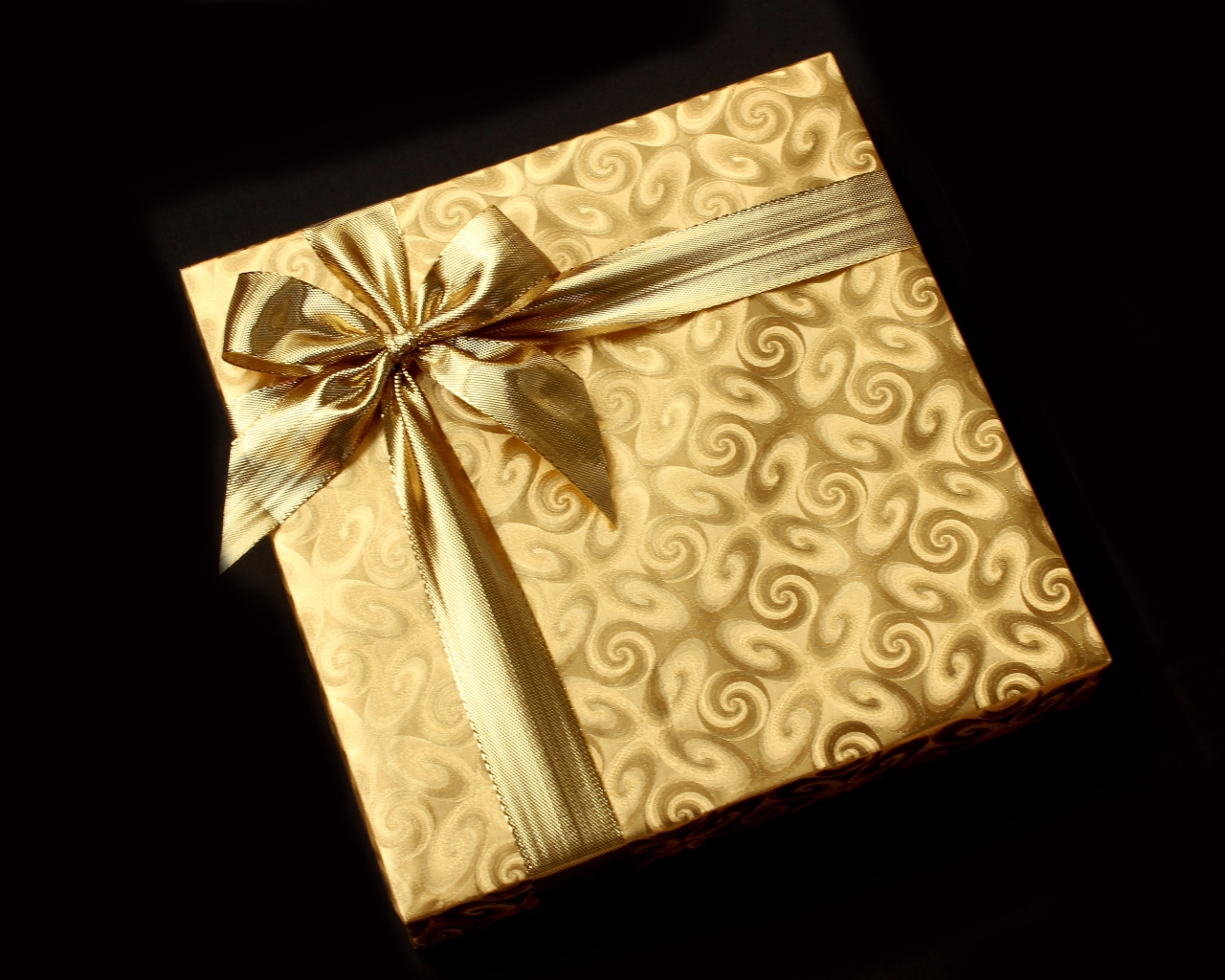 Золотая упаковка с подарком на черном фоне