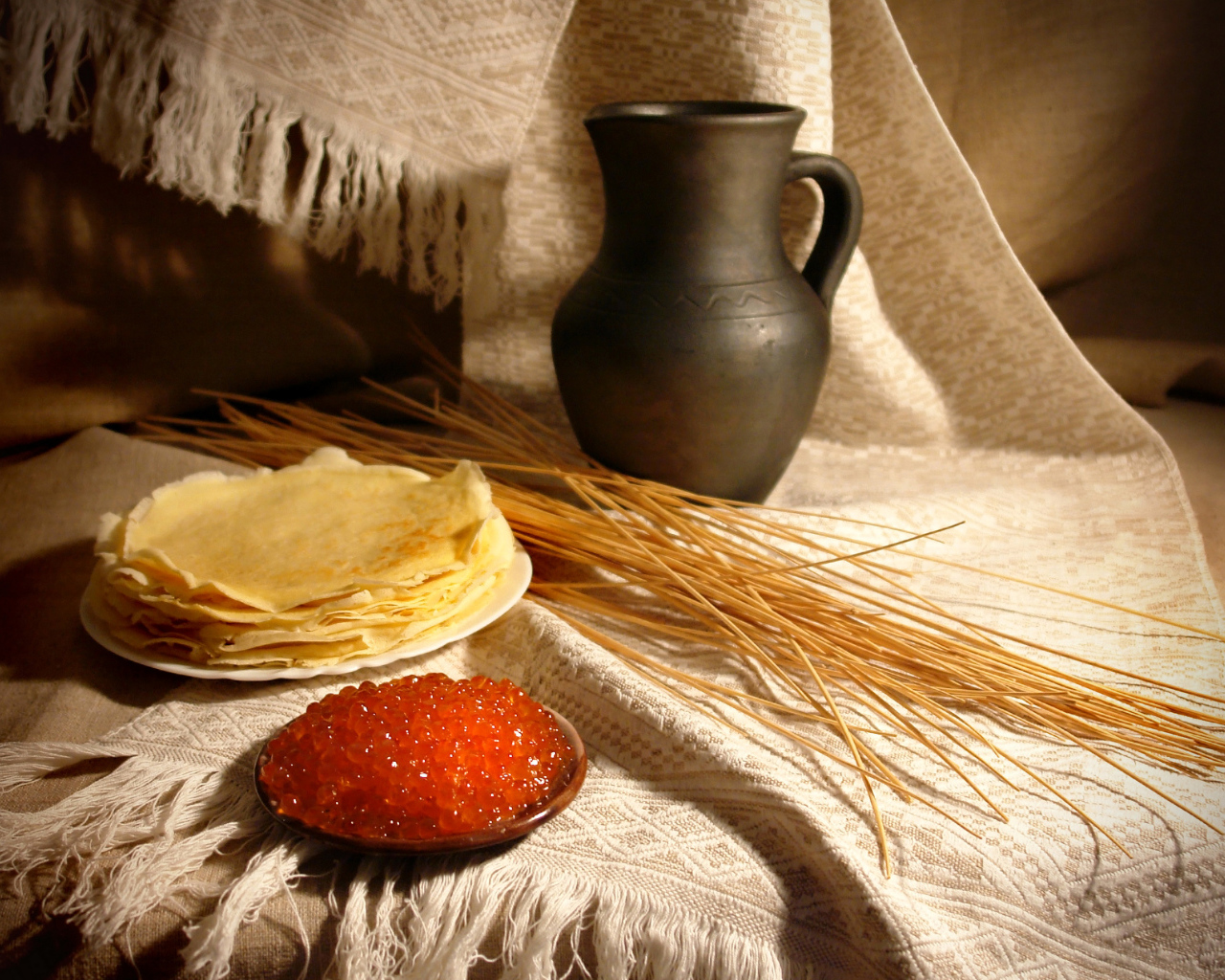 Блины с икрой на столе с колосьями на праздник Масленица