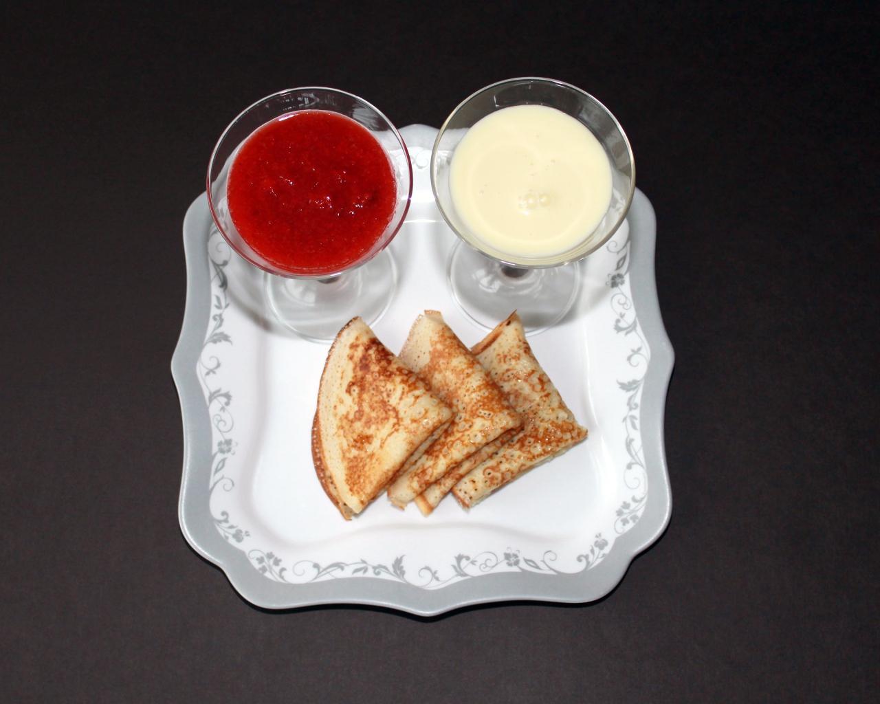 Блинчики с вареньем и сметаной на столе на Масленицу