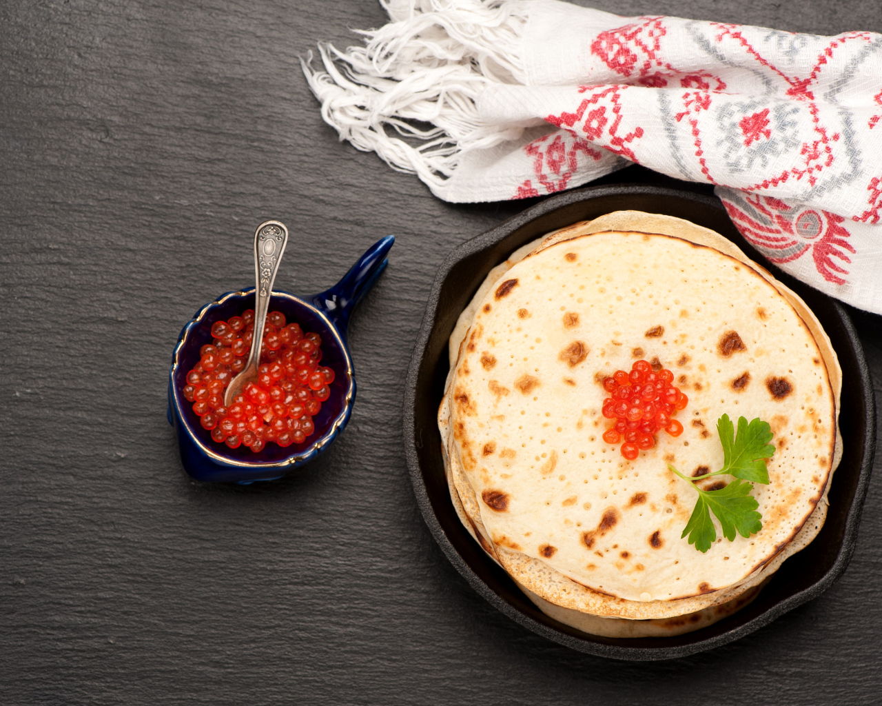 Тонкие блинчики с красной икрой на столе