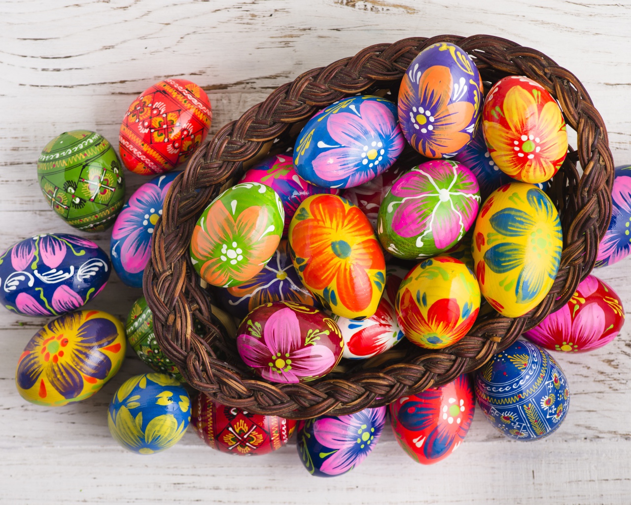 Красивые крашеные яйца в корзине на столе на праздник Великой Пасхи