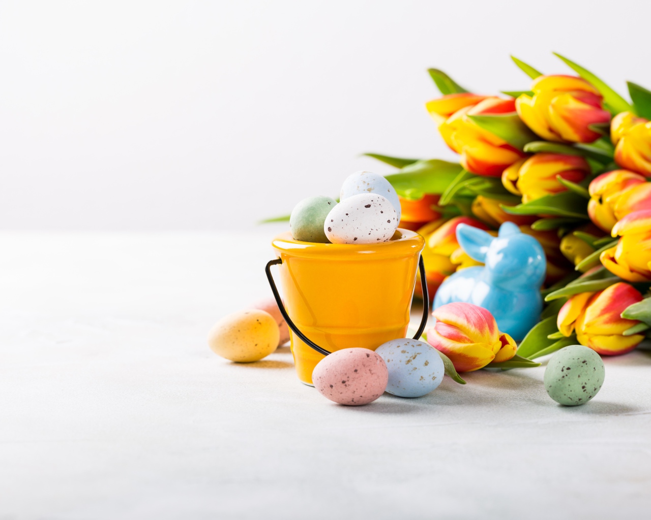 Букет тюльпанов на белом фоне с крашеными яйцами на Пасху