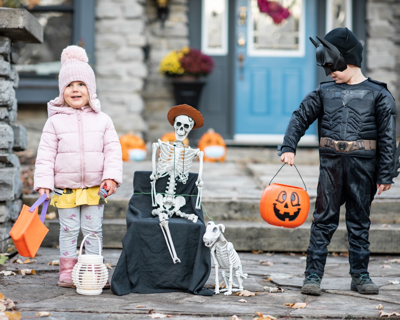 Маленькие дети со скелетом на праздник Хэллоуин