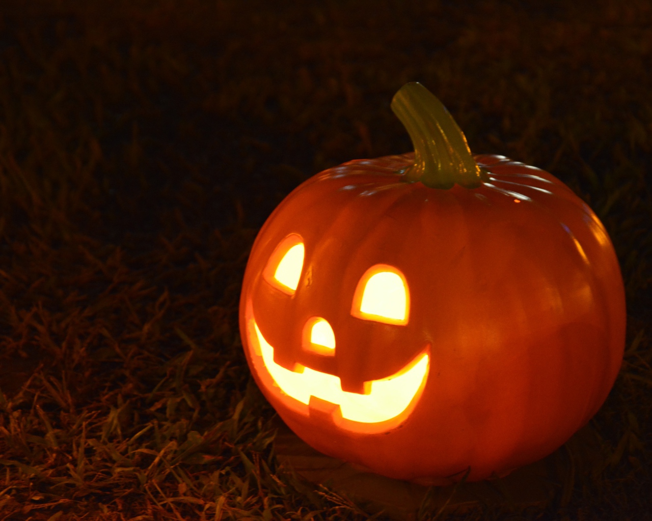 Светильник из тыквы на черном фоне на праздник Хэллоуин