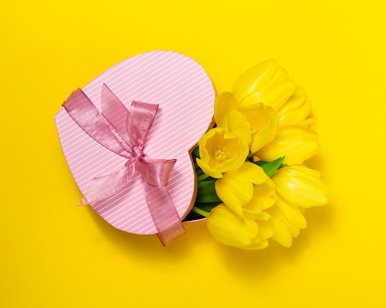 Подарок и букет тюльпанов на желтом фоне на Международный женский день