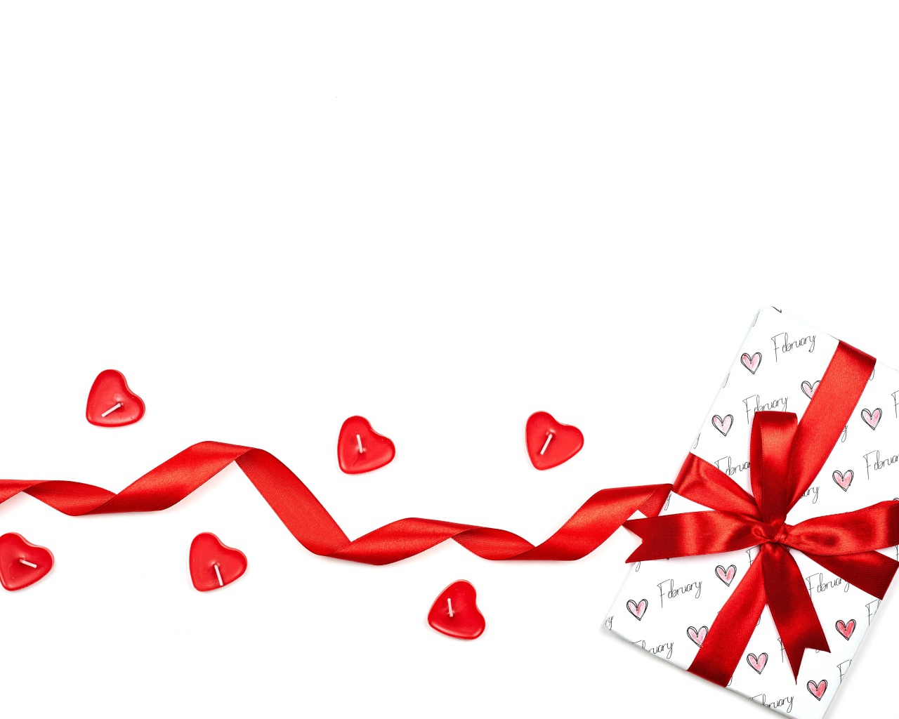 Подарок с красной лентой и свечами на белом фоне на День Святого Валентина