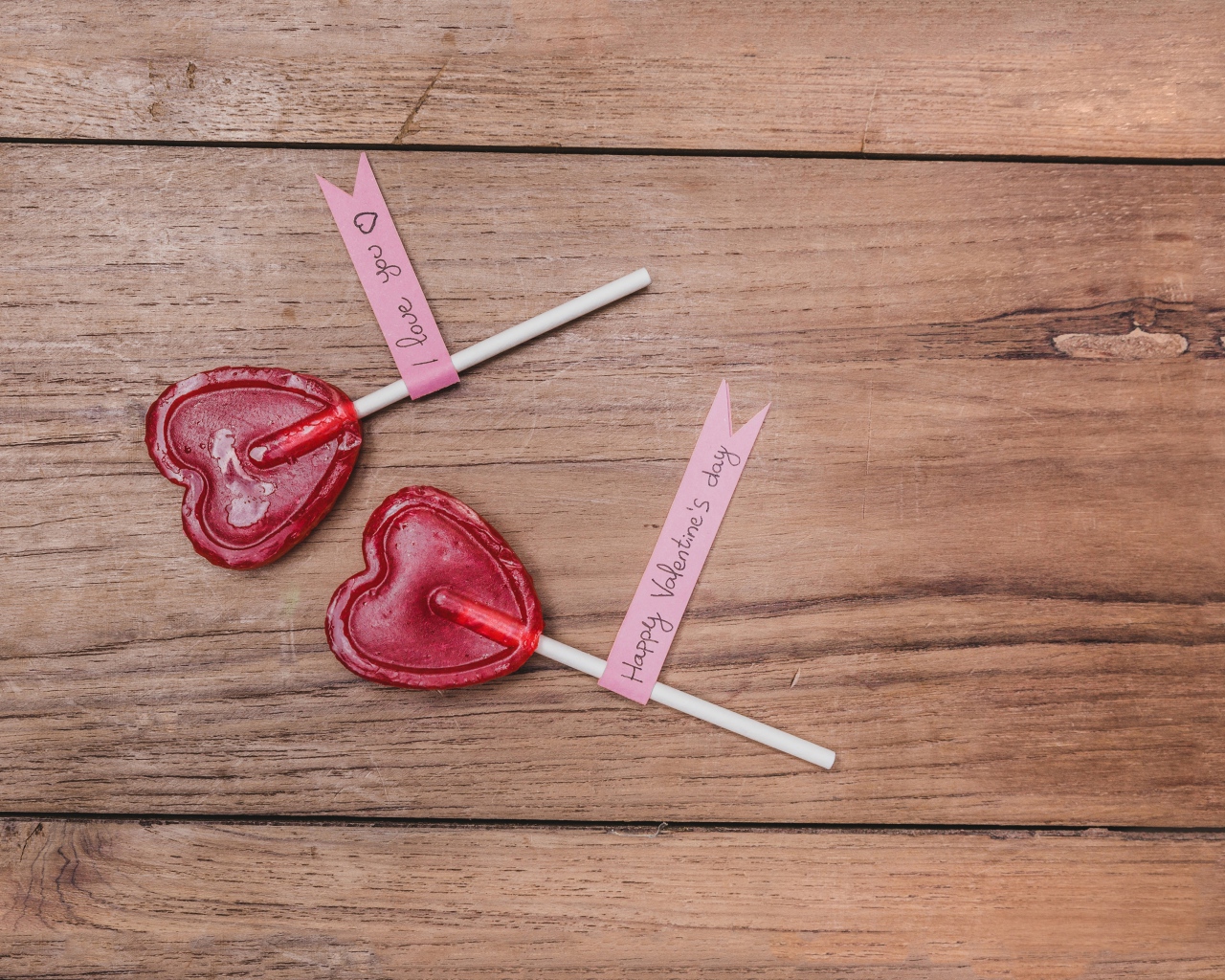 Два красных леденца для любимой на деревянном столе