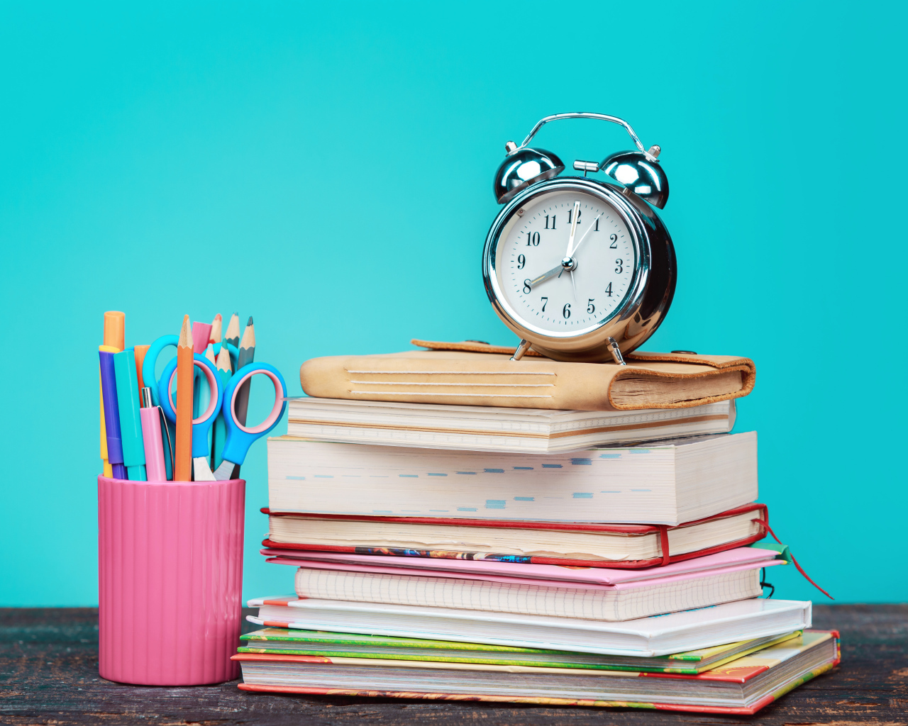 Будильник, книги и канцелярские предметы для школы