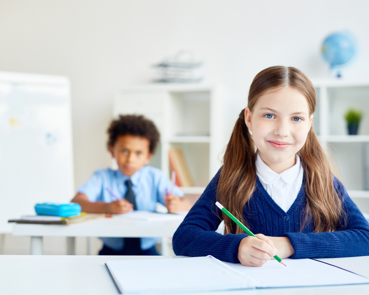 Девочка школьница сидит за партой в школе 