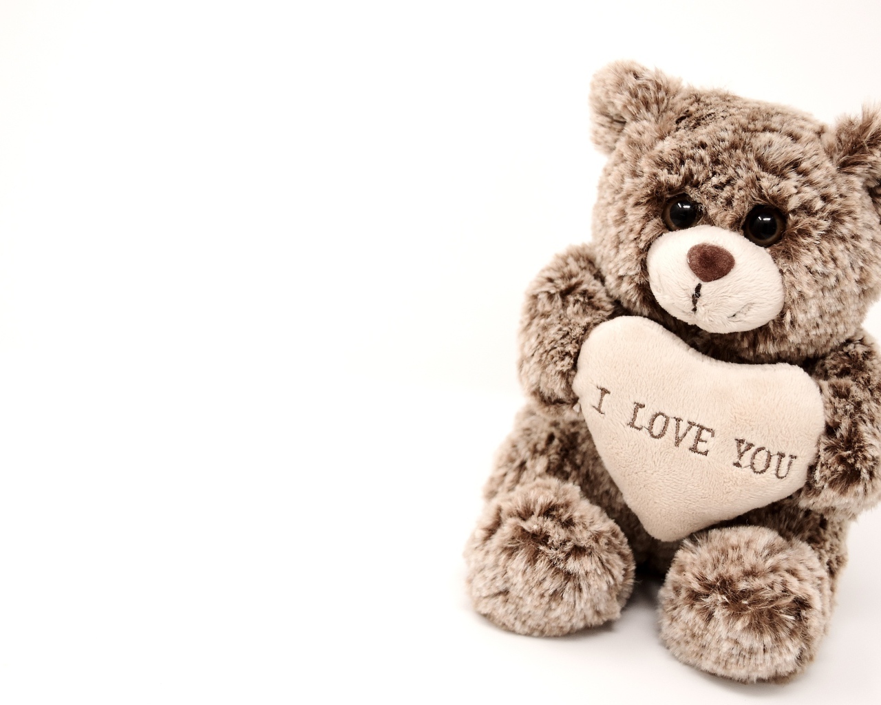 Меховая игрушка медвежонок с сердцем на белом фоне