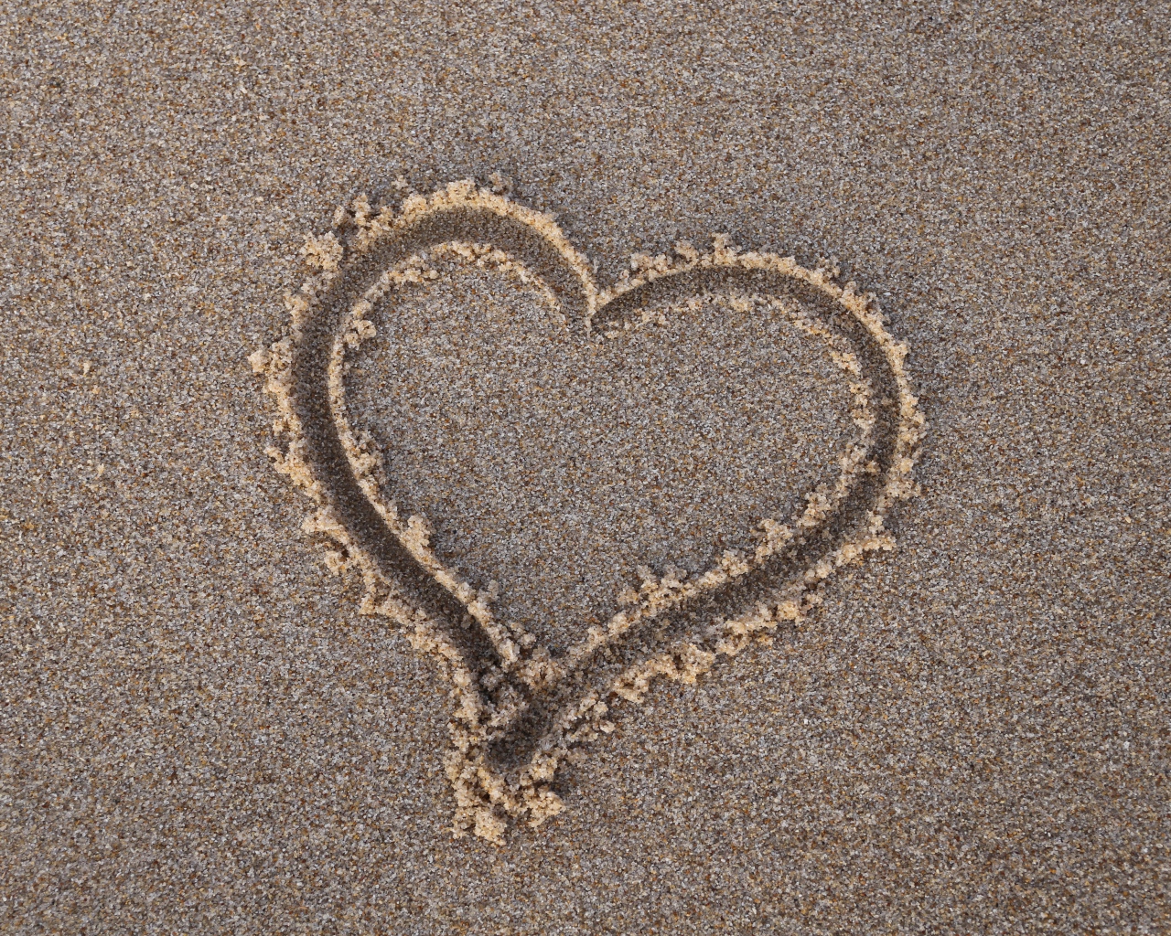 Сердце нарисовано на мокром песке 