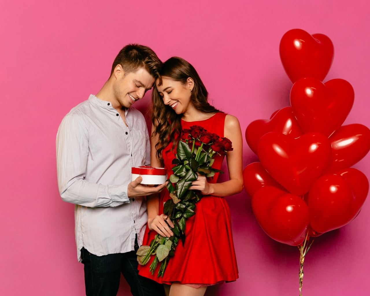 Влюбленная пара с воздушными шариками на розовом фоне 