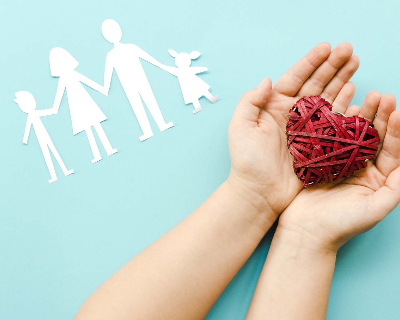 Плетеное сердце в руках на голубом фоне