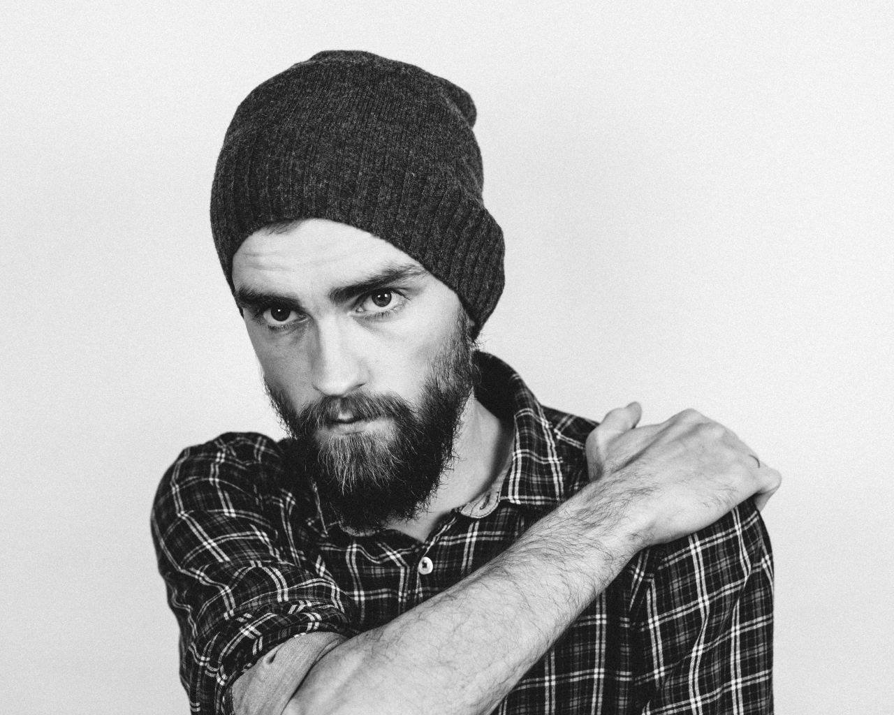 Бородатый мужчина в шапке на белом фоне 