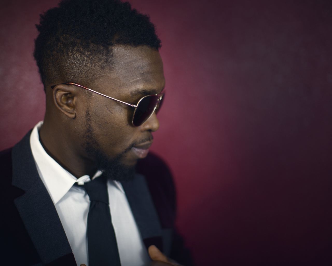 Темнокожий мужчина в костюме и очках 