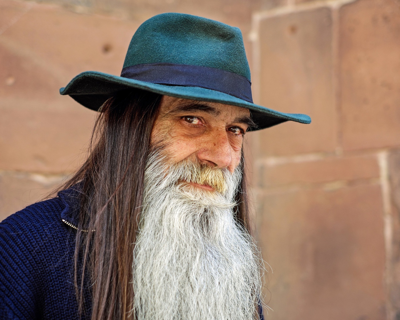 Пожилой мужчина с длинными волосами в шляпе 