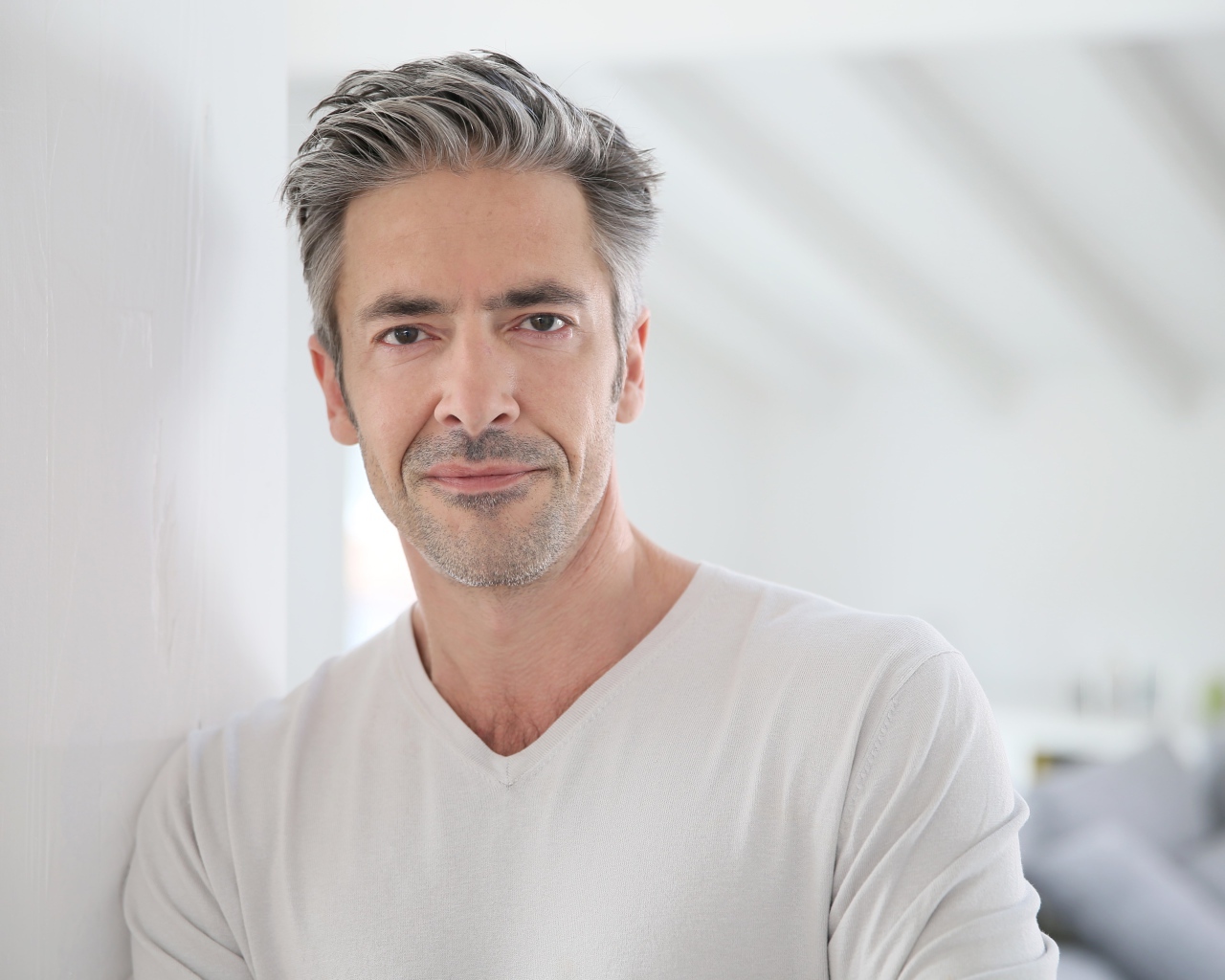 Седой стильный мужчина у стены