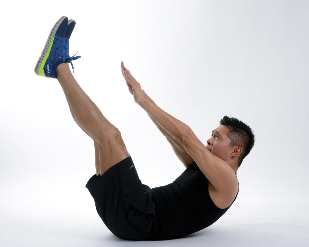 Мужчина спортсмен качает пресс на белом фоне