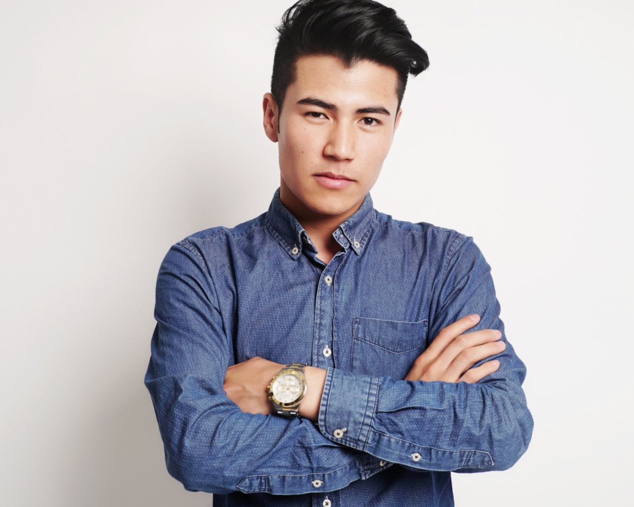 Мужчина в синей рубашке на сером фоне 