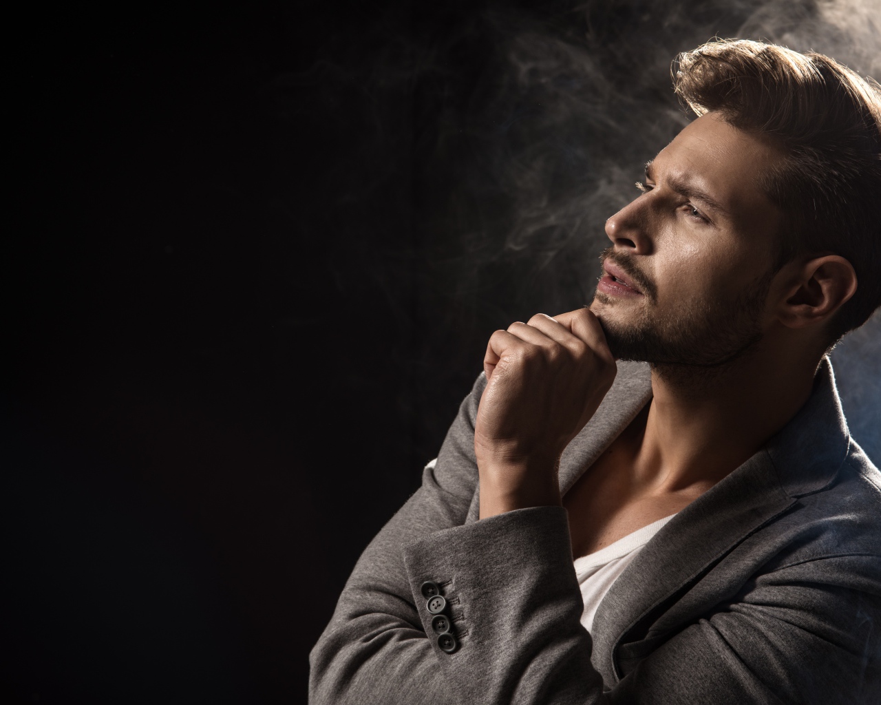 Задумчивый взгляд мужчины на черном фоне 