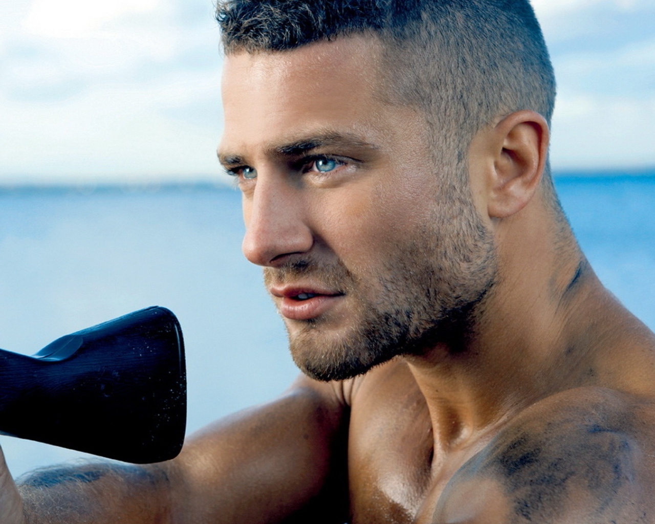 Сильный голубоглазый мужчина с винтовкой в руках 