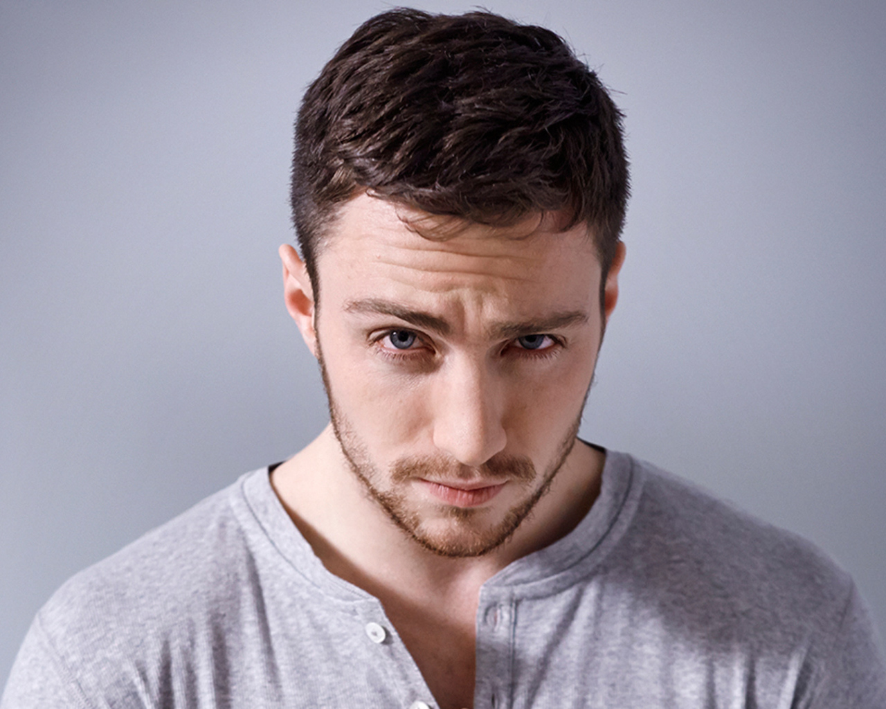 Молодой голубоглазый мужчина на сером фоне