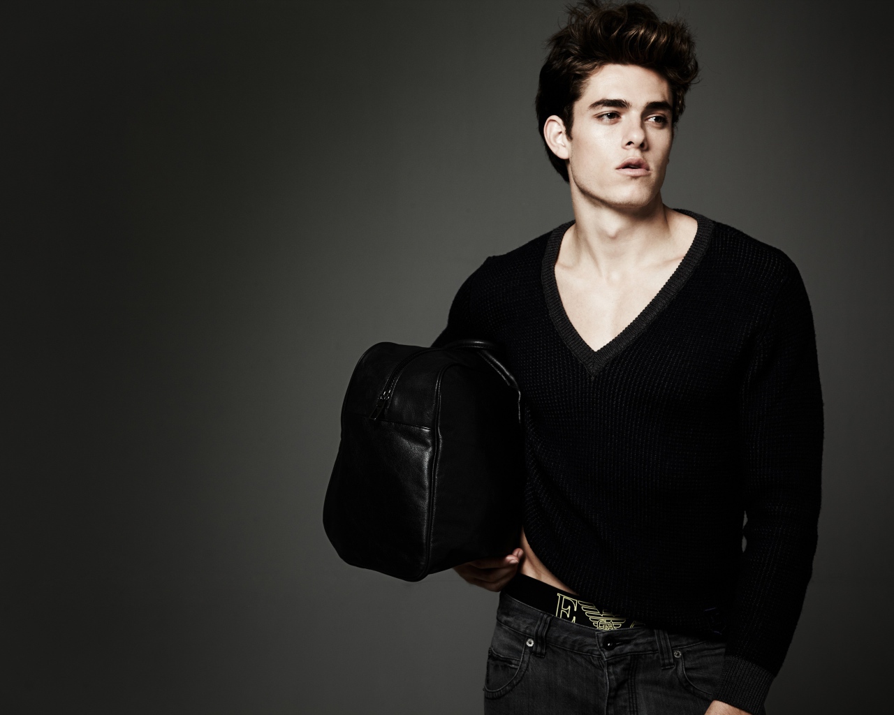 Молодой мужчина с черной сумкой в руке 