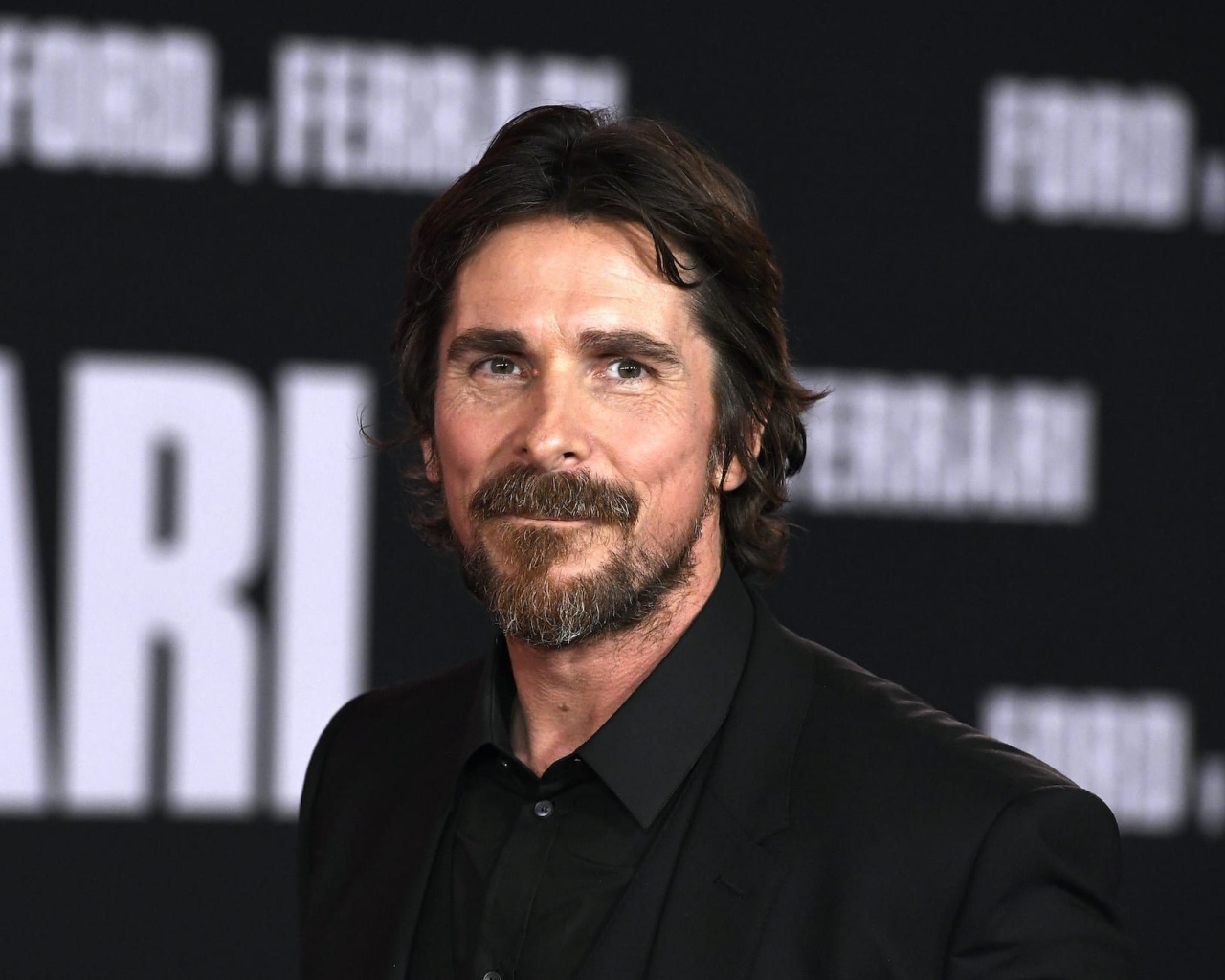 Актер Кристиан Бэйл в черном костюме