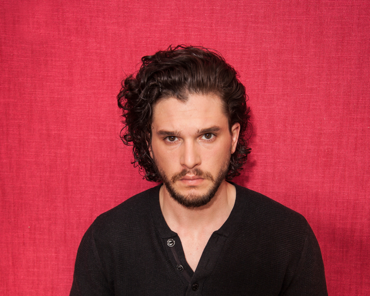 Актер  Кит Харингтон на розовом фоне