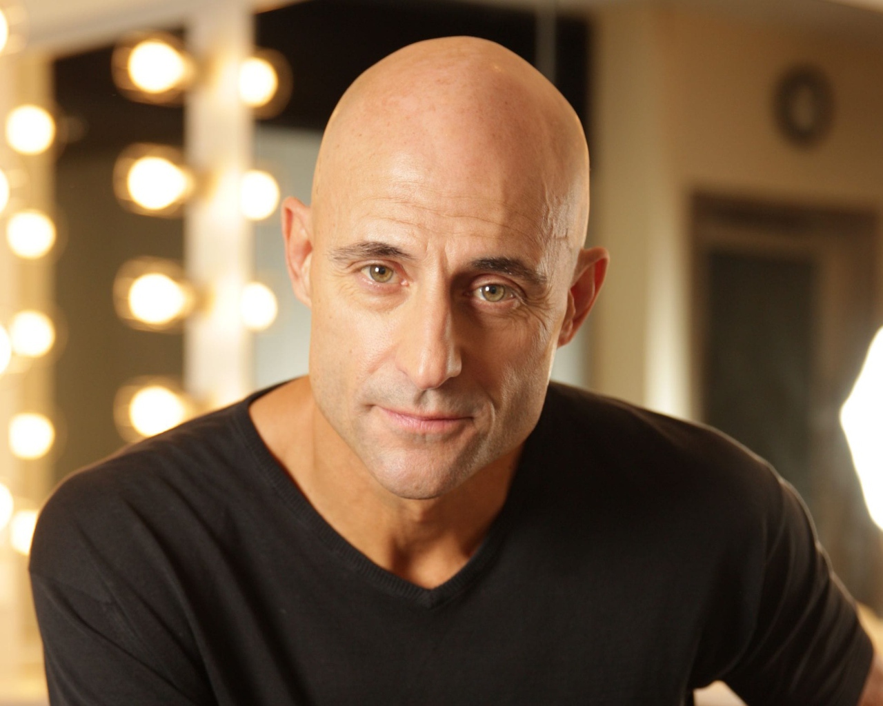 Актер Марк Стронг на фоне лампочек