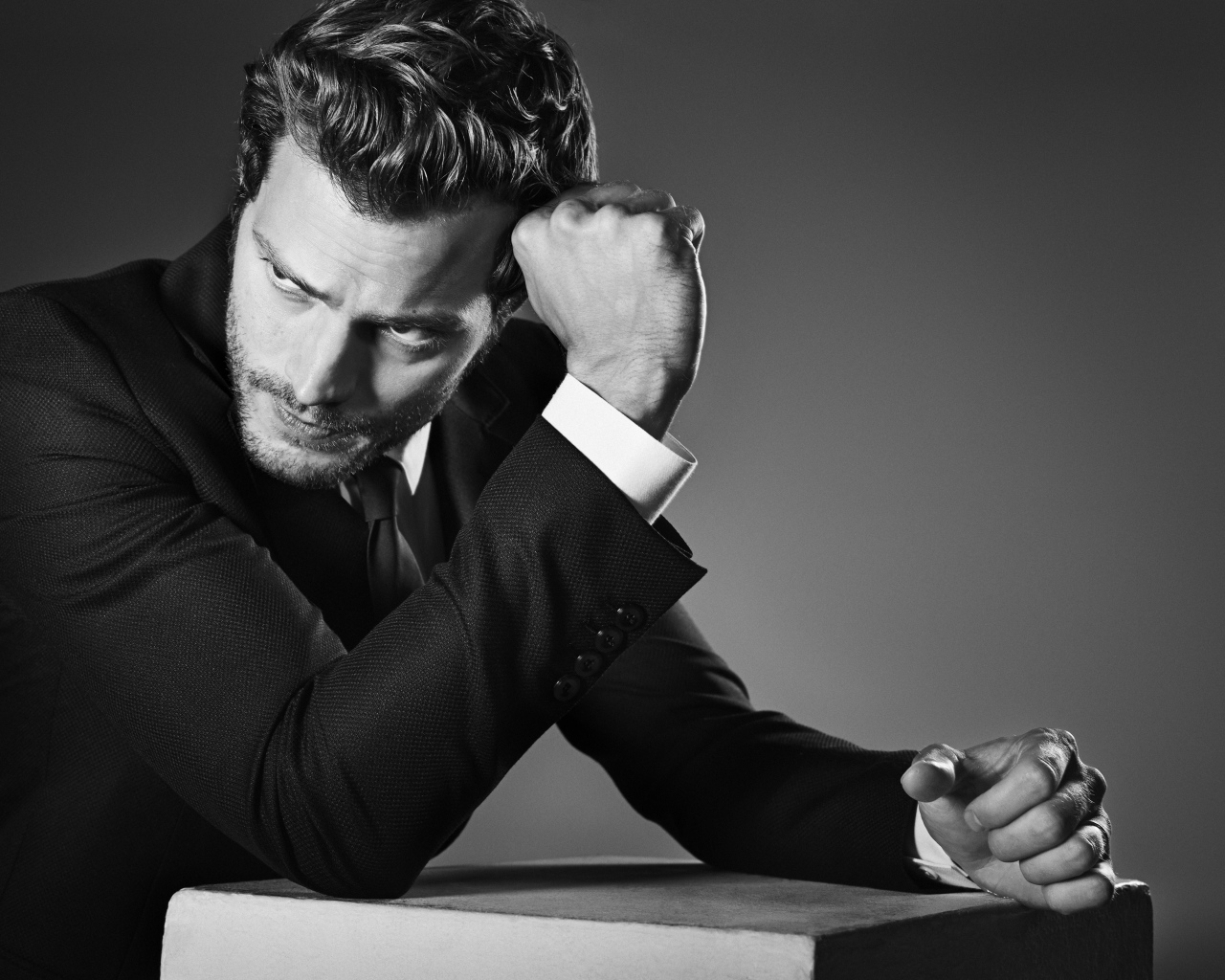 Британский актер Джейми Дорнан на сером фоне