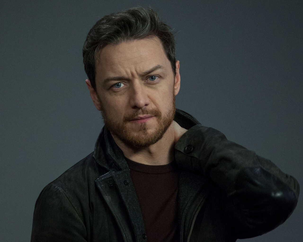 Красивый мужчина, актер Джеймс МакЭвой на сером фоне