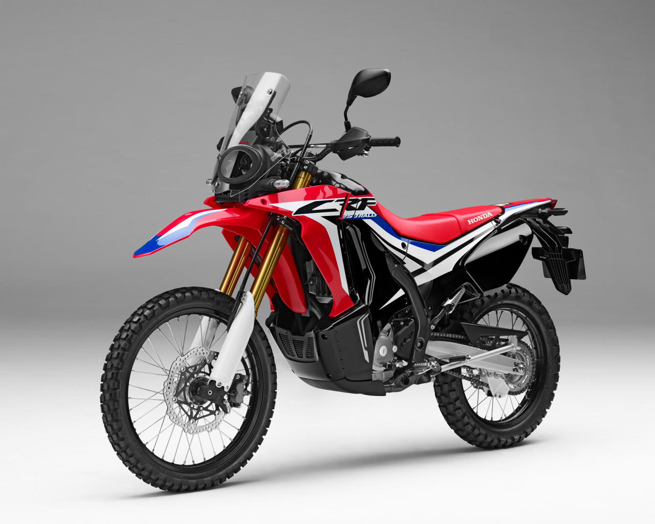 Спортивный мотоцикл Honda crf250l Rally на сером фоне