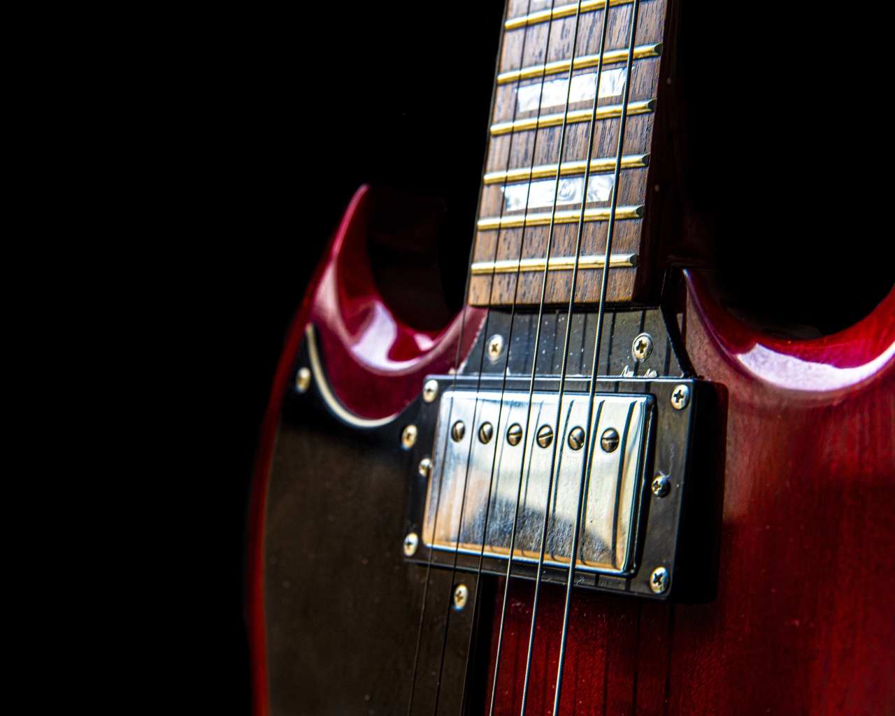 Красная гитара со струнами на черном фоне 