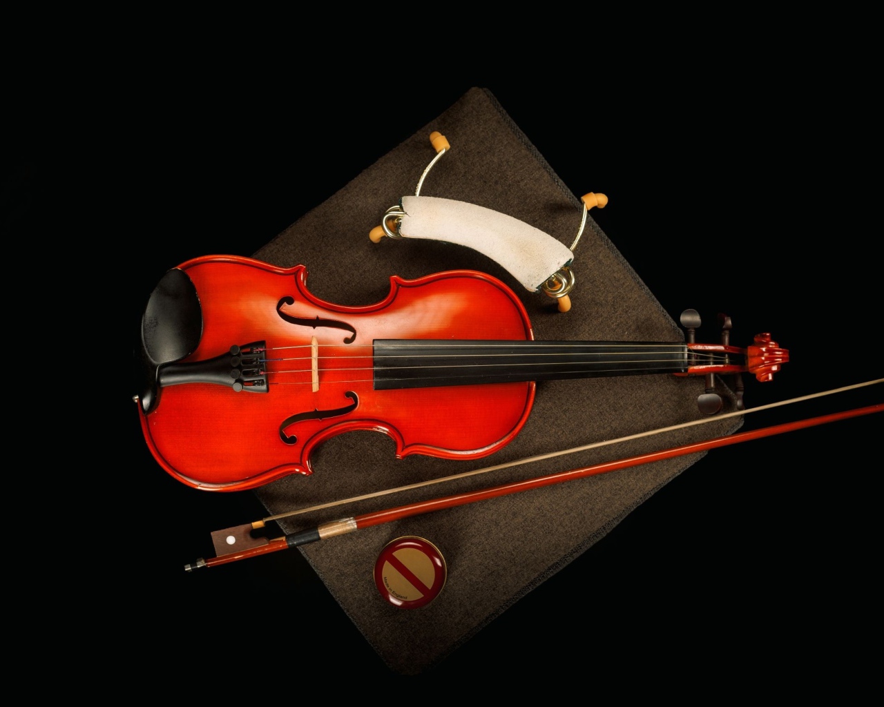 Красная скрипка со смычком на черном фоне